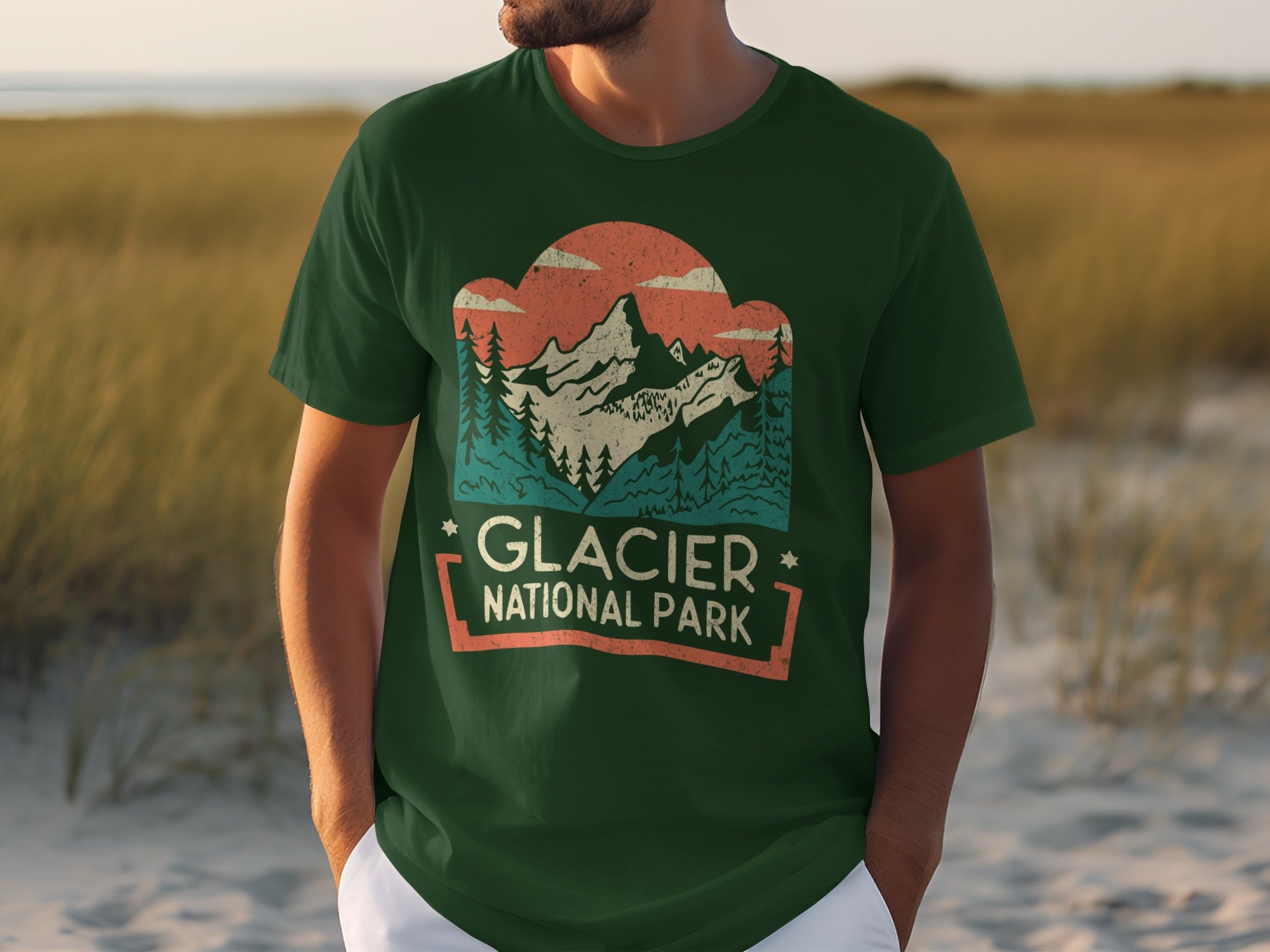 Green t-shirt with Glacier National Park graphic featuring mountains, trees, and clouds.