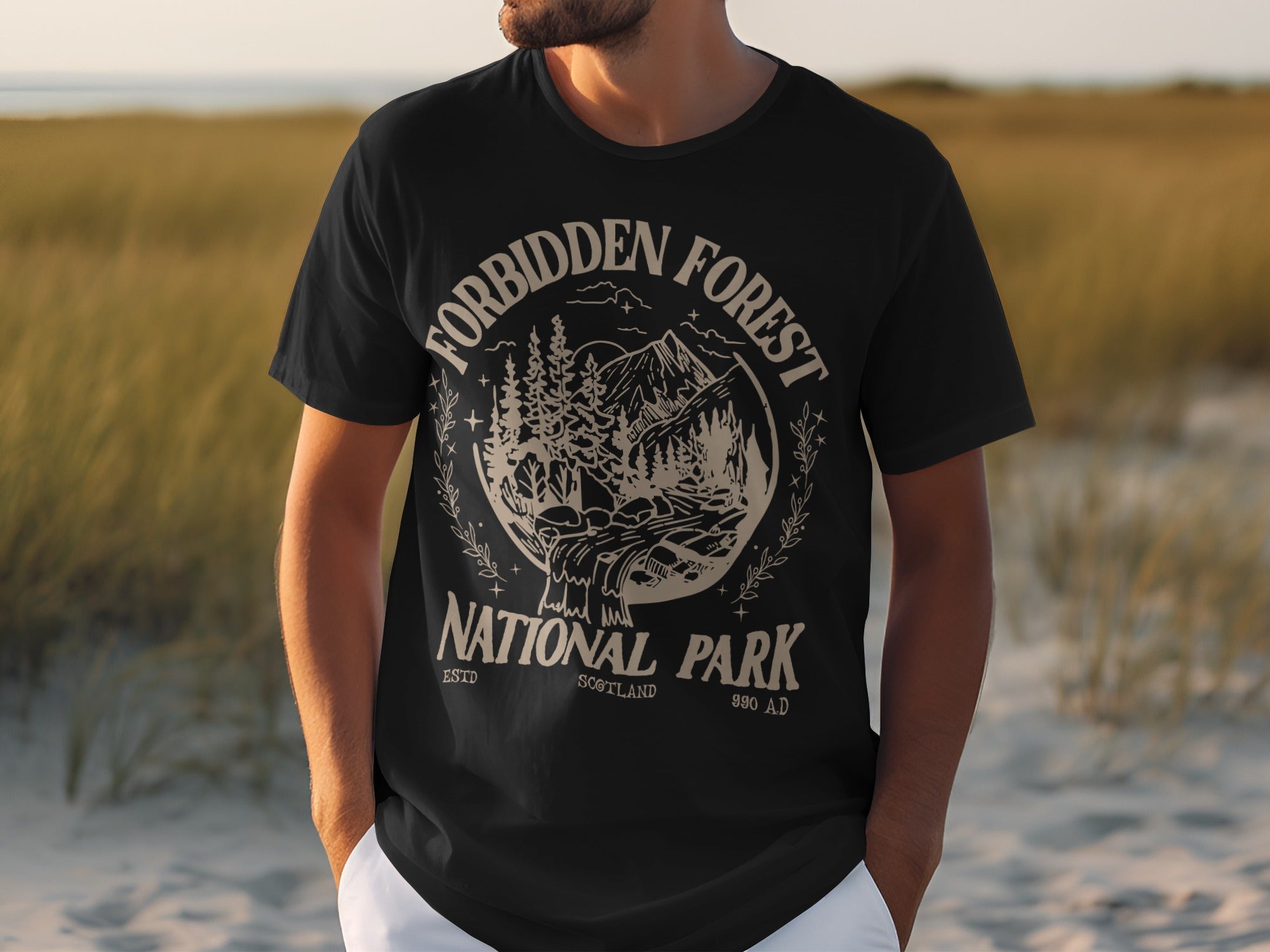 Black t-shirt with "Forbidden Forest National Park Scotland 990 AD" text and nature graphic.