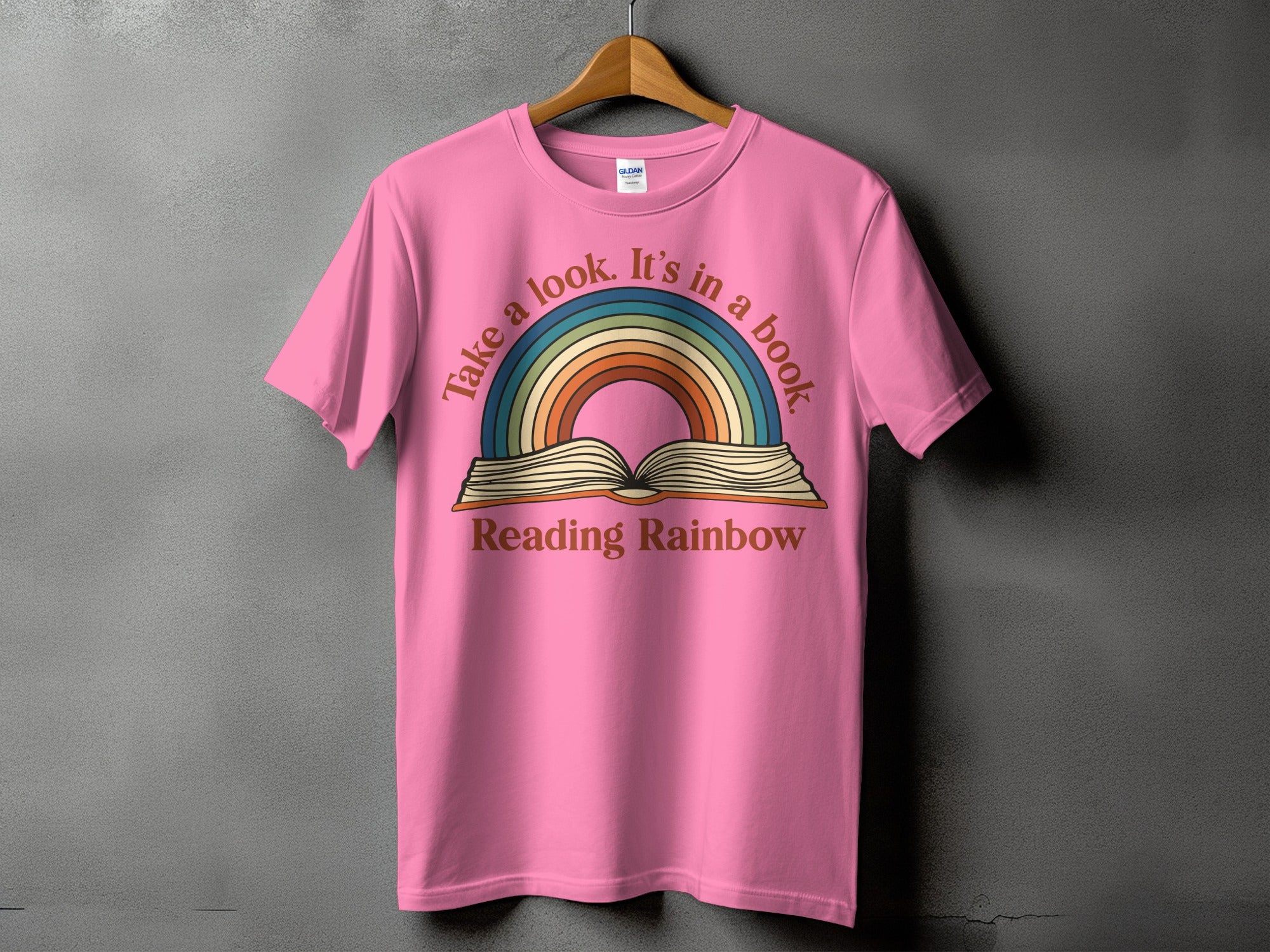 Pink t-shirt with "Take a look. It's in a book Reading Rainbow" graphic.