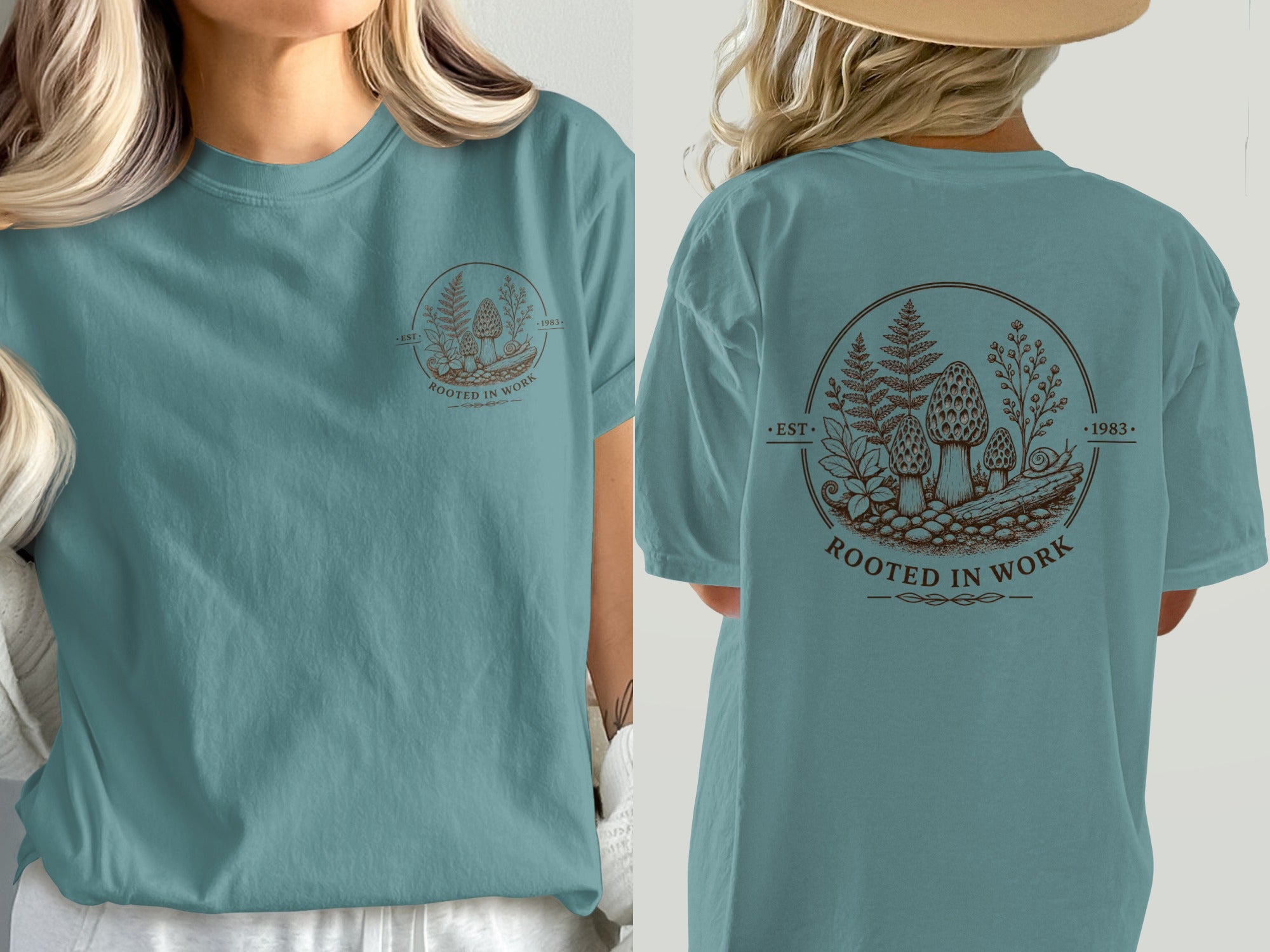 Teal t-shirt featuring a circular graphic with mushrooms, ferns, and the text "Rooted in Work".