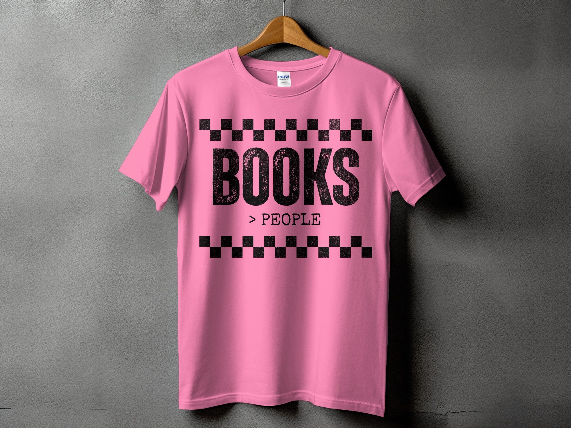 Pink t-shirt with black text "BOOKS > PEOPLE" and checkered borders.