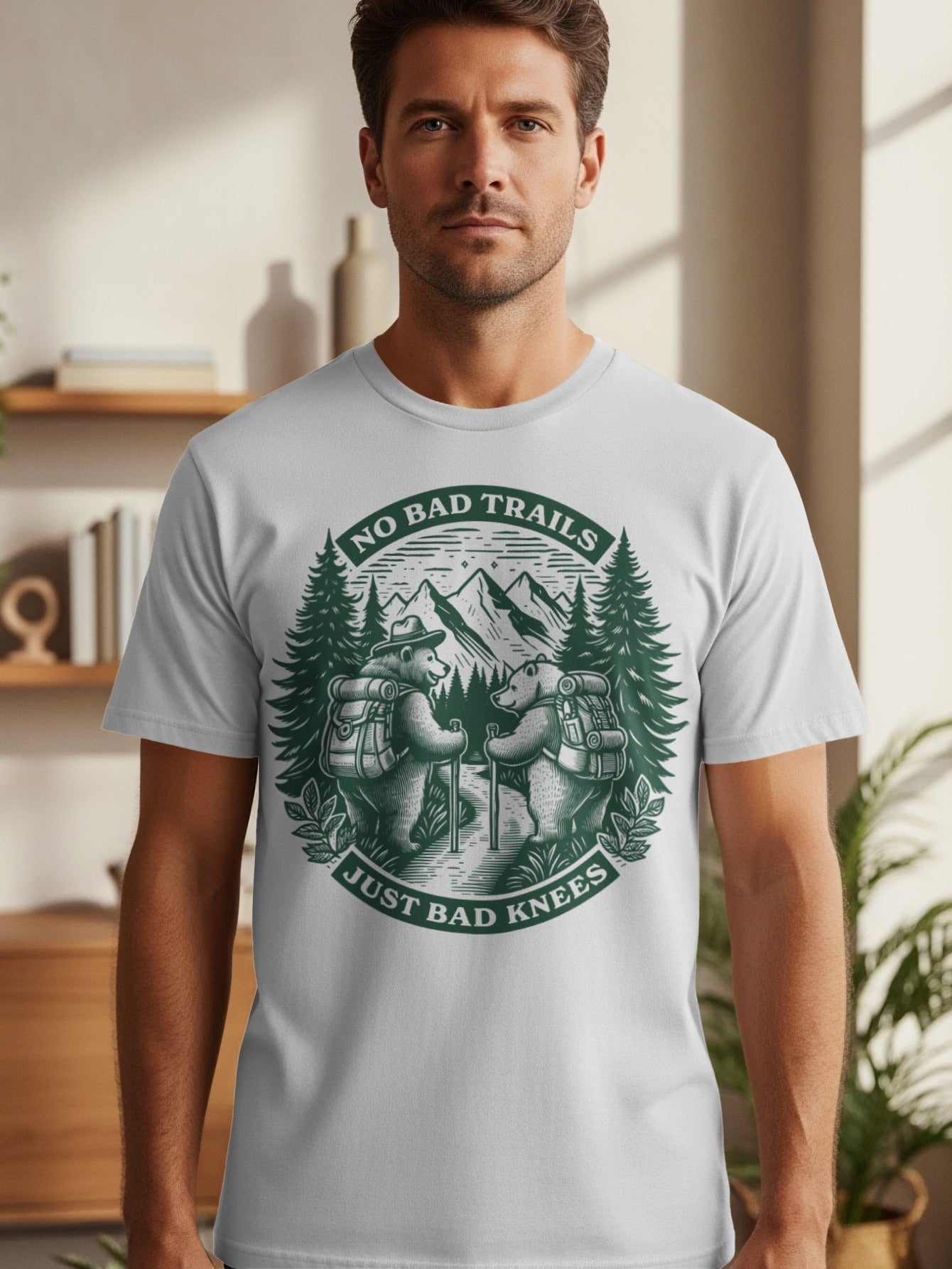T-shirt graphic with two bears hiking in mountains, text reads "No Bad Trails Just Bad Knees".