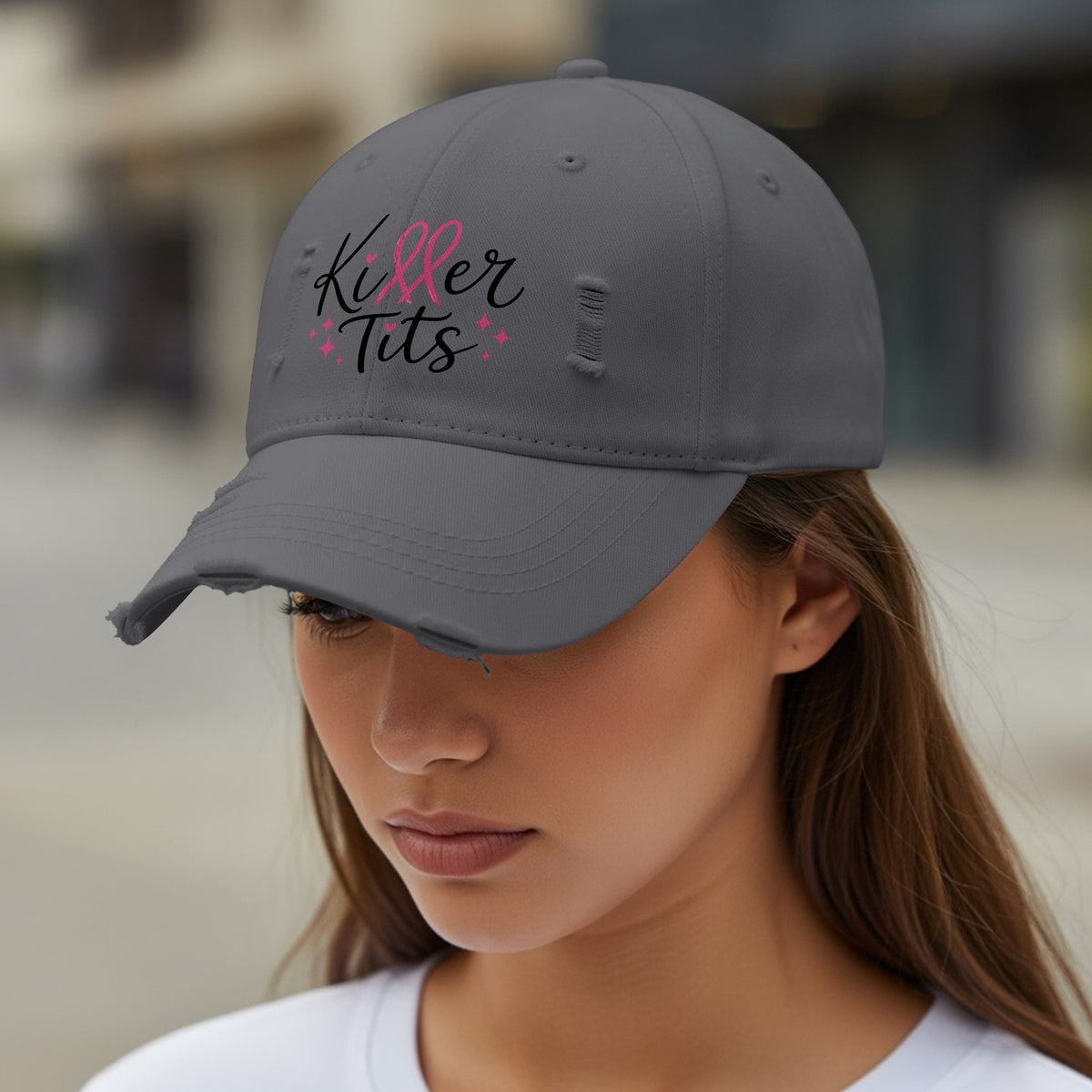 Distressed grey baseball cap with "Killer Tits" in pink and black text.
