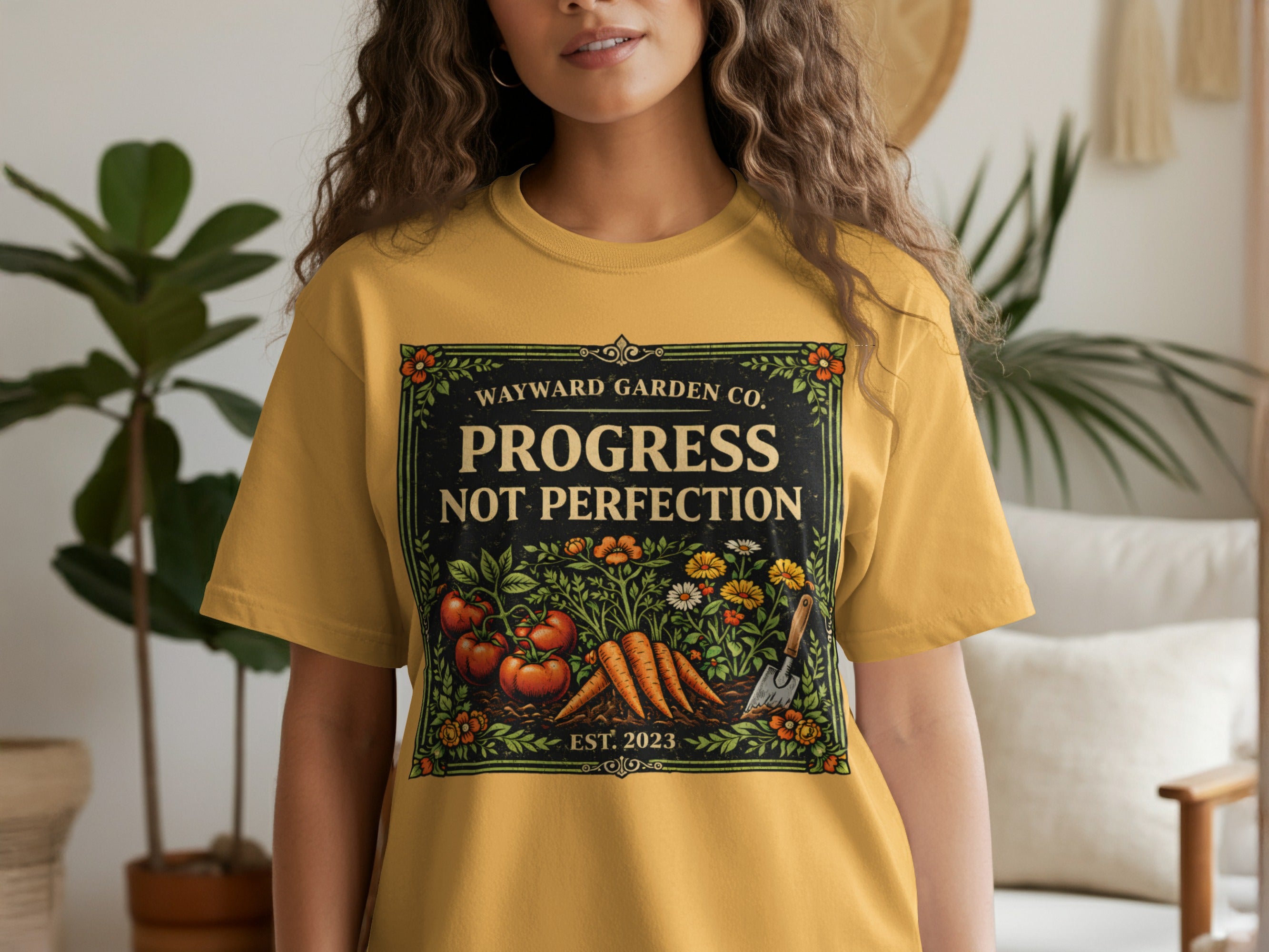 Yellow t-shirt with "Wayward Garden Co. Progress Not Perfection" and garden art.
