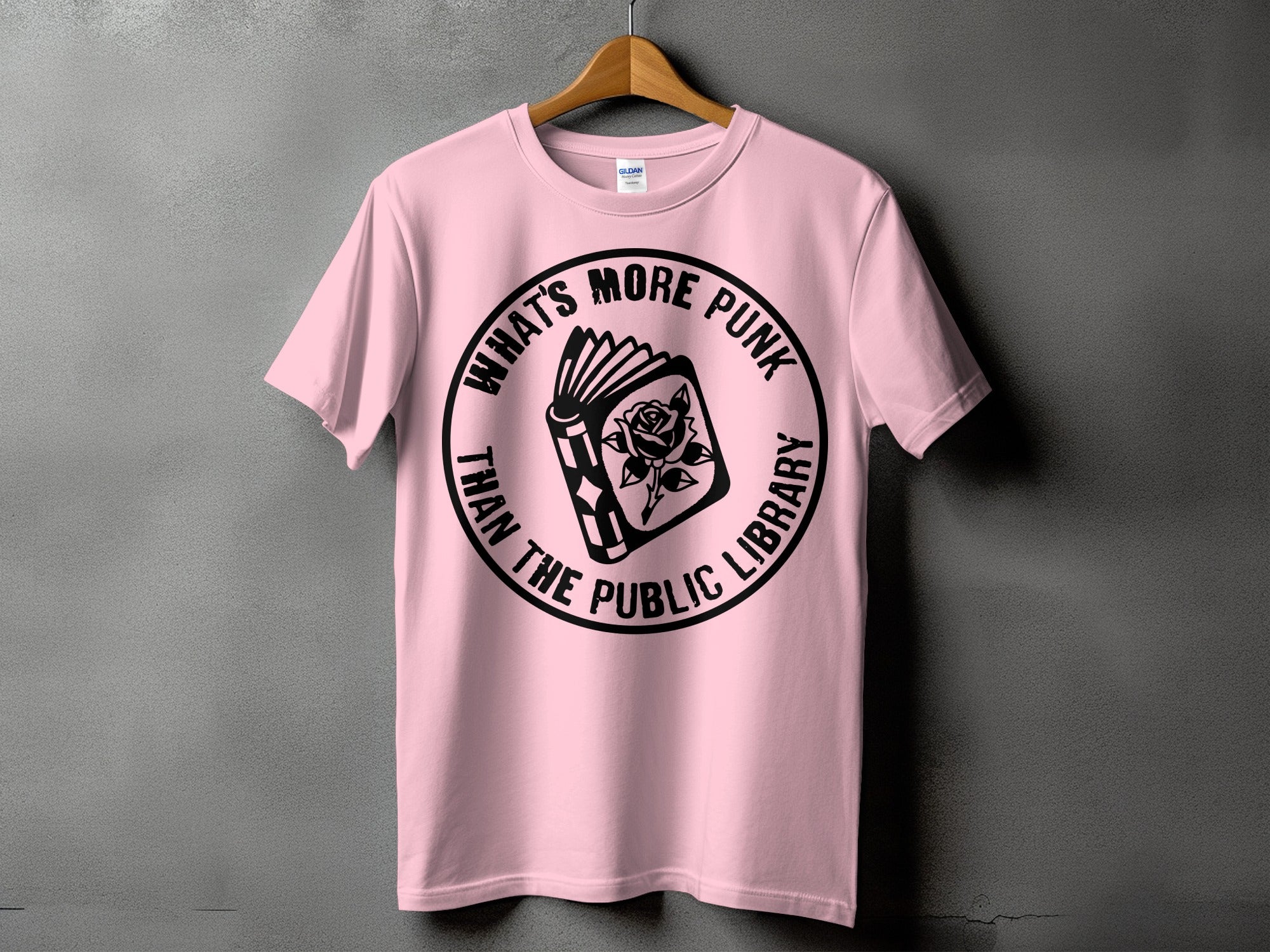 Pink t-shirt with black graphic: book with rose and text "WHAT'S MORE PUNK THAN THE PUBLIC LIBRARY".