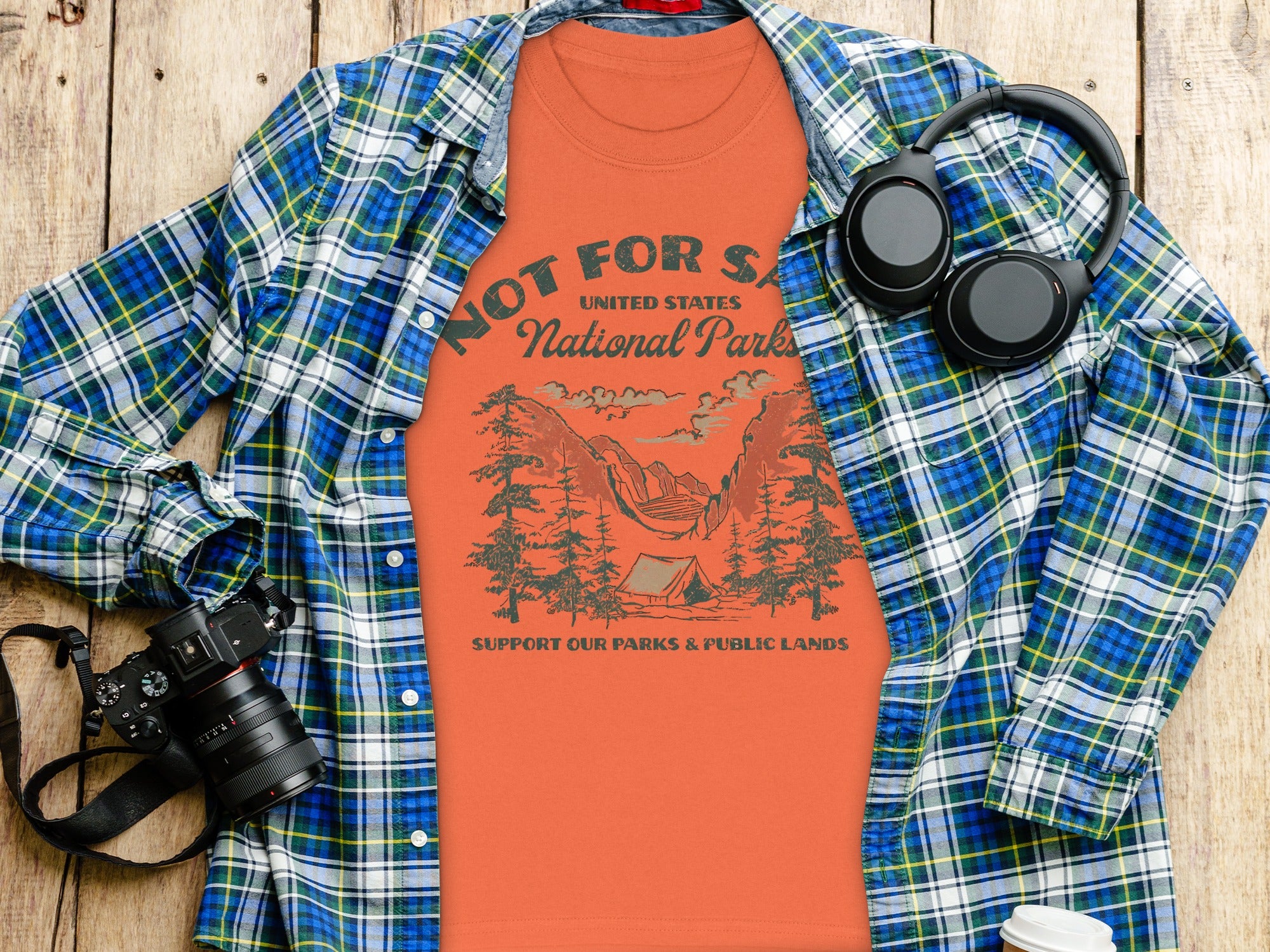 Orange t-shirt with "National Parks" graphic and a plaid shirt.