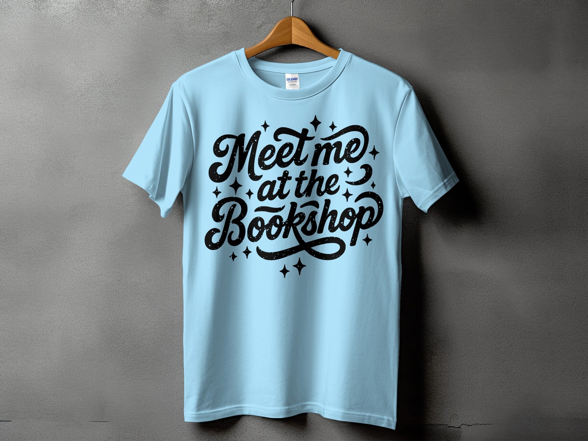 Light blue t-shirt with black text reading "Meet me at the Bookshop"