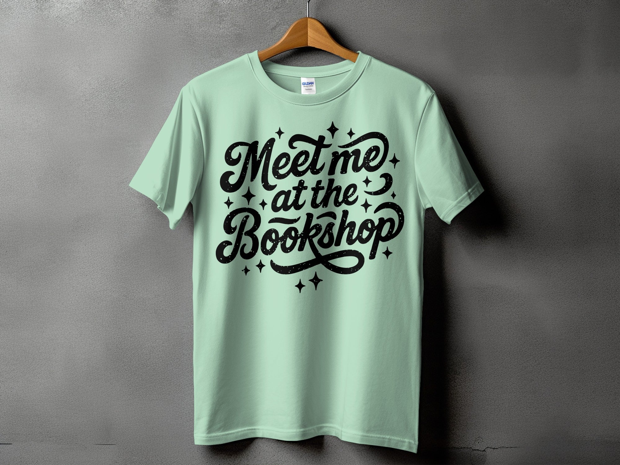 Light mint t-shirt with black text "Meet me at the Bookshop" and stars.