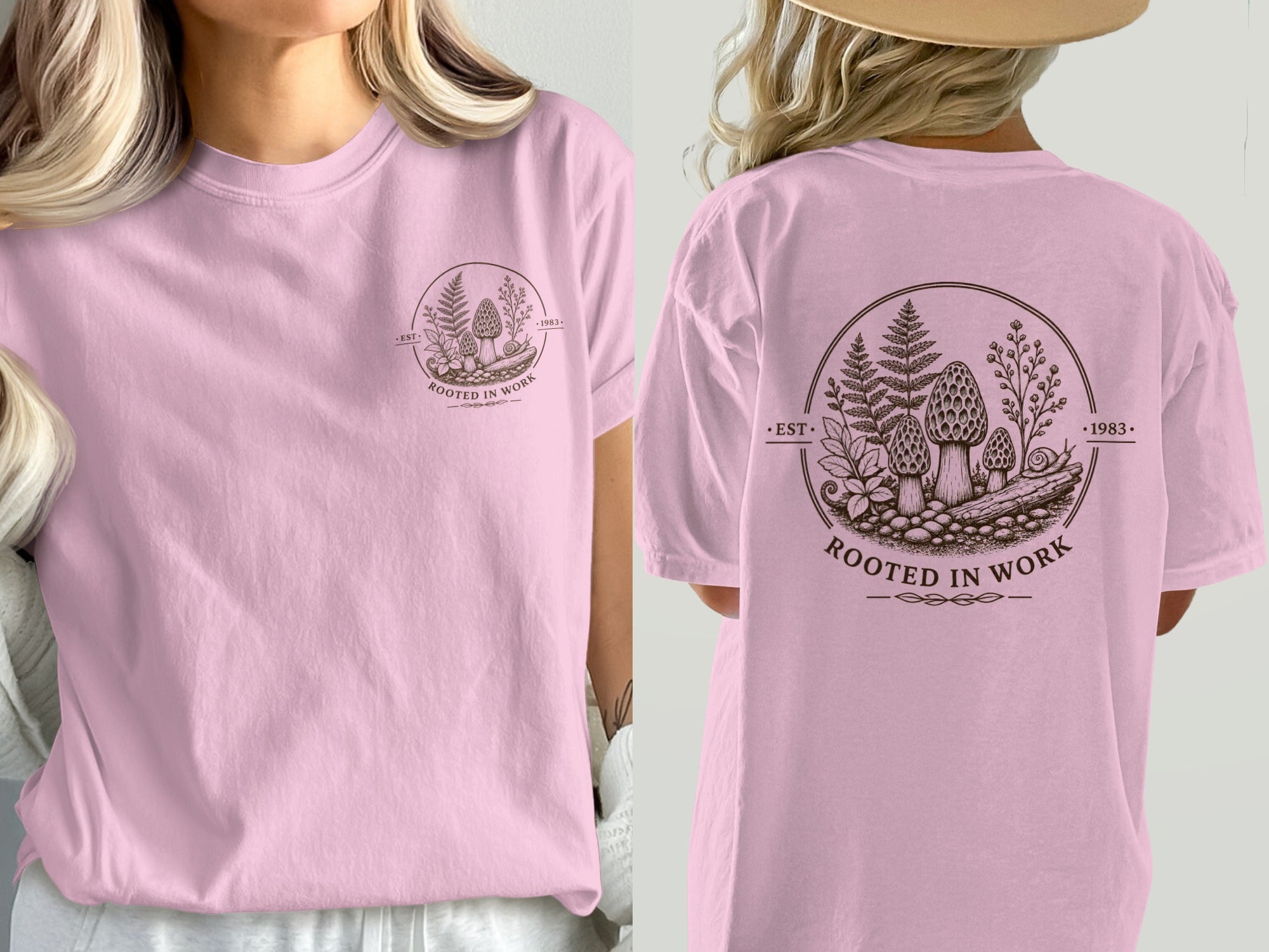 Pink t-shirt with circular nature graphic featuring mushrooms and text "ROOTED IN WORK".