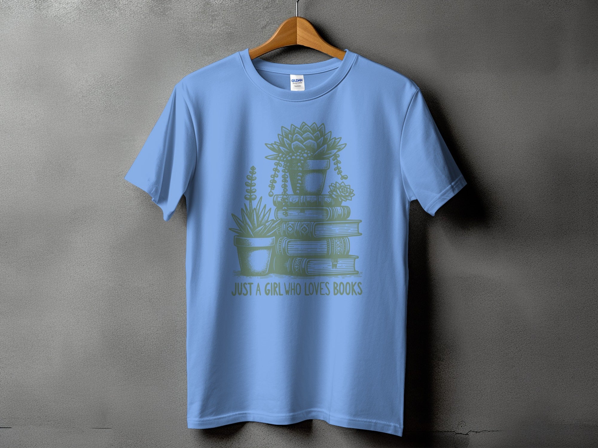 Light blue t-shirt with stack of books and plants graphic and text "JUST A GIRL WHO LOVES BOOKS".
