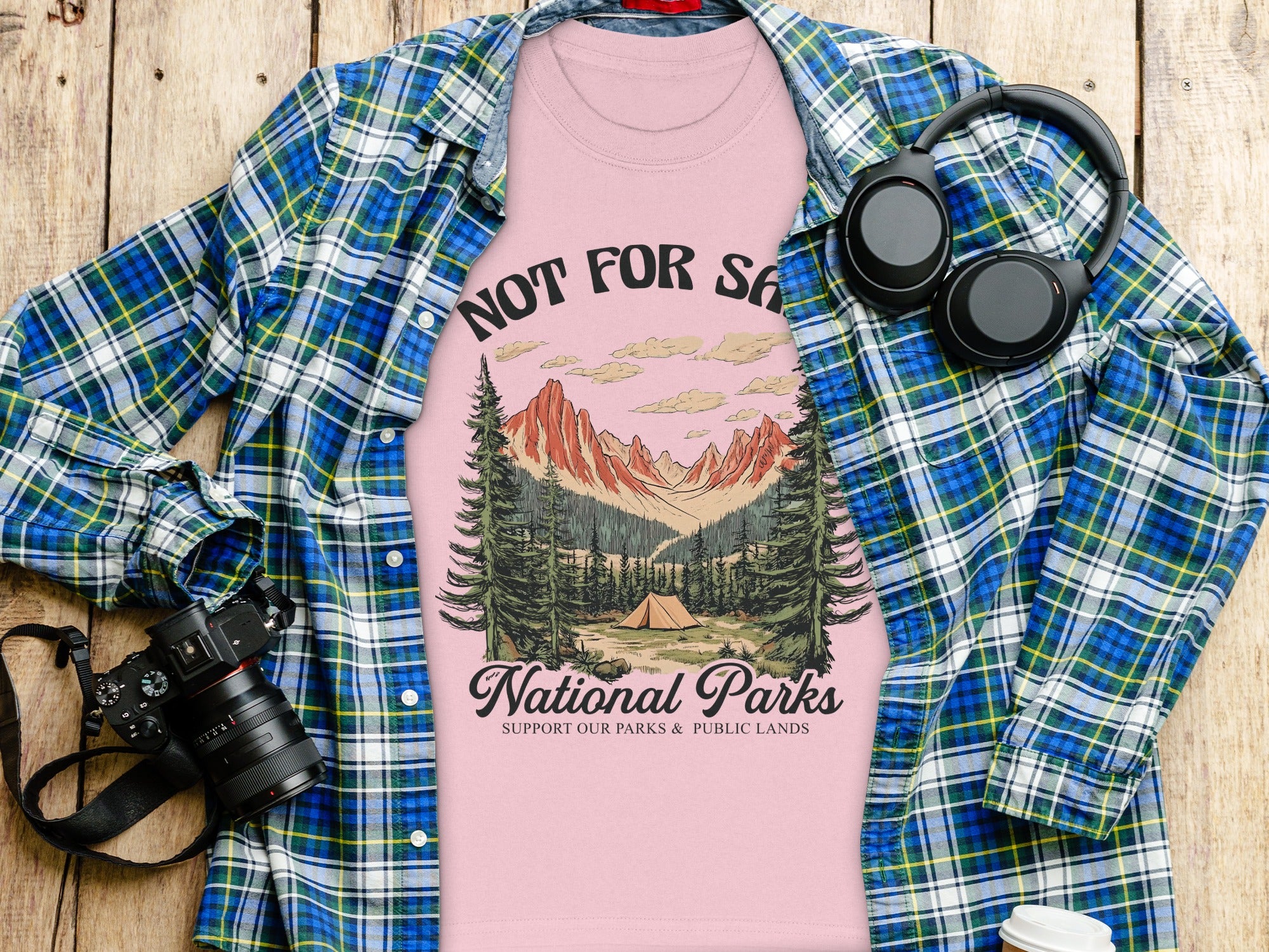 Pink t-shirt with "National Parks" graphic and open plaid shirt.