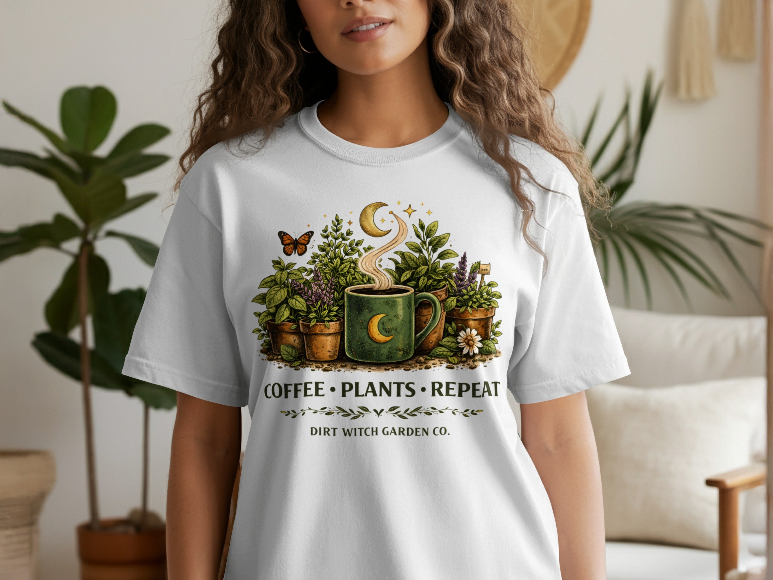 White t-shirt with "Coffee Plants Repeat" slogan and plant, moon, and butterfly graphic.