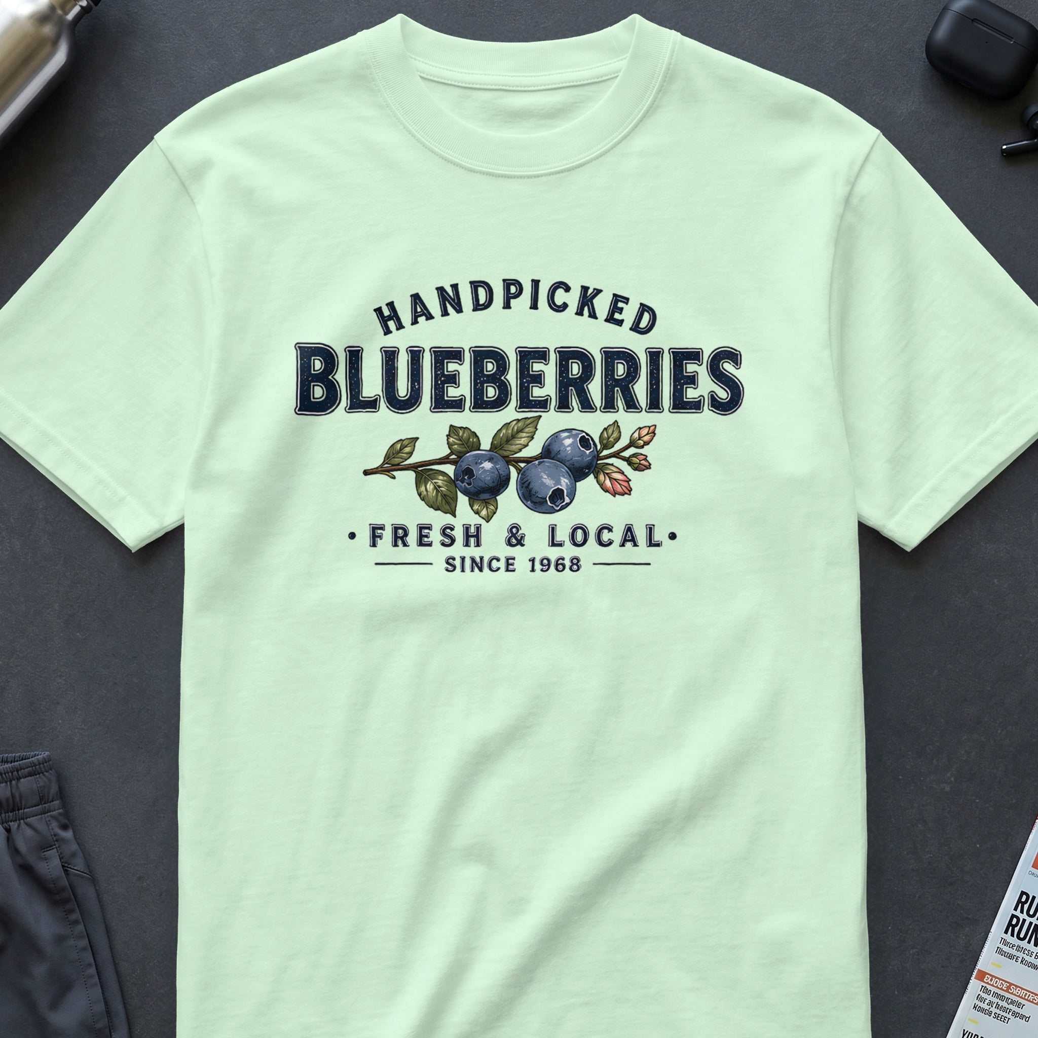 Light blue t-shirt with "Handpicked Blueberries Fresh & Local Since 1968" graphic.