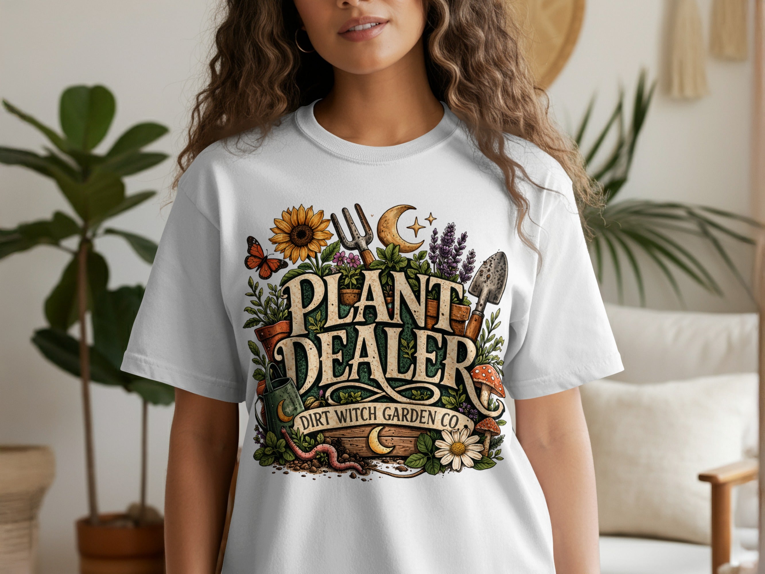 White t-shirt with "PLANT DEALER DIRT WITCH GARDEN CO." text and garden graphics.