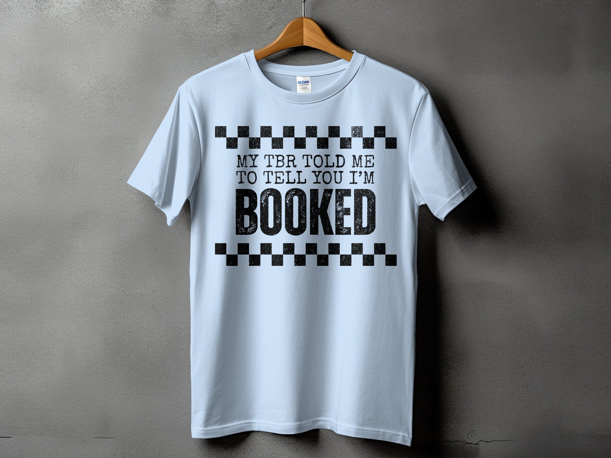Light blue t-shirt with "My TBR told me to tell you I'm BOOKED" printed on it.
