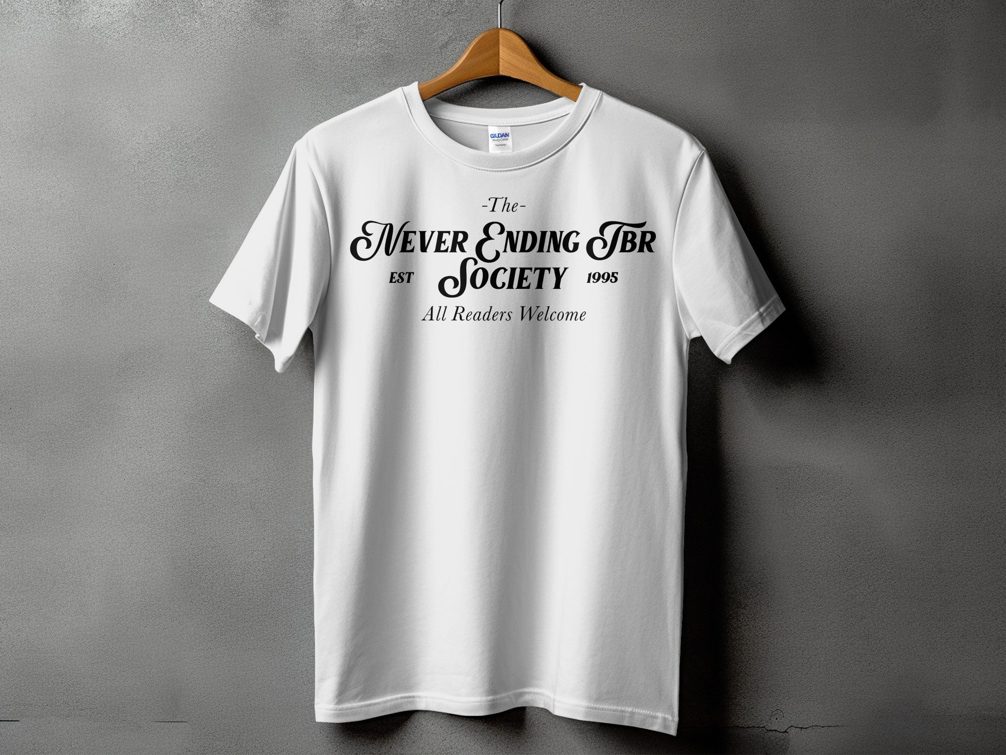 White t-shirt with black text: "The Never Ending TBR Society EST 1995 All Readers Welcome"