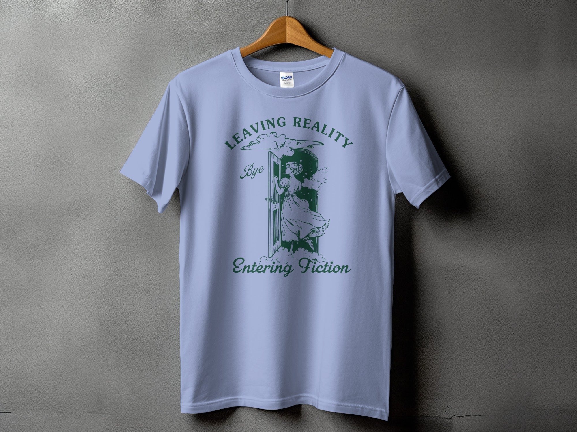 Light blue t-shirt with green text and illustration: "Leaving Reality Bye Entering Fiction".