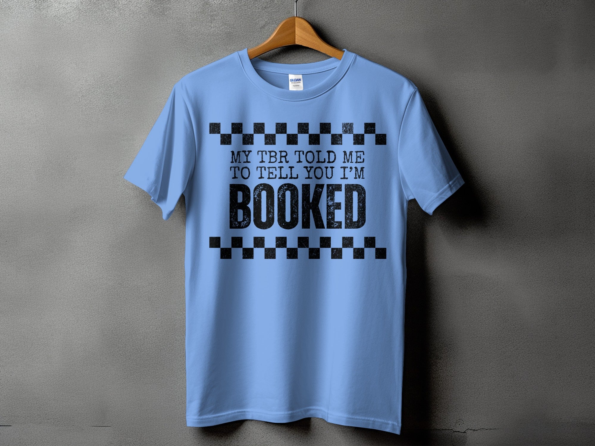 Light blue t-shirt with black text: "MY TBR TOLD ME TO TELL YOU I'M BOOKED".