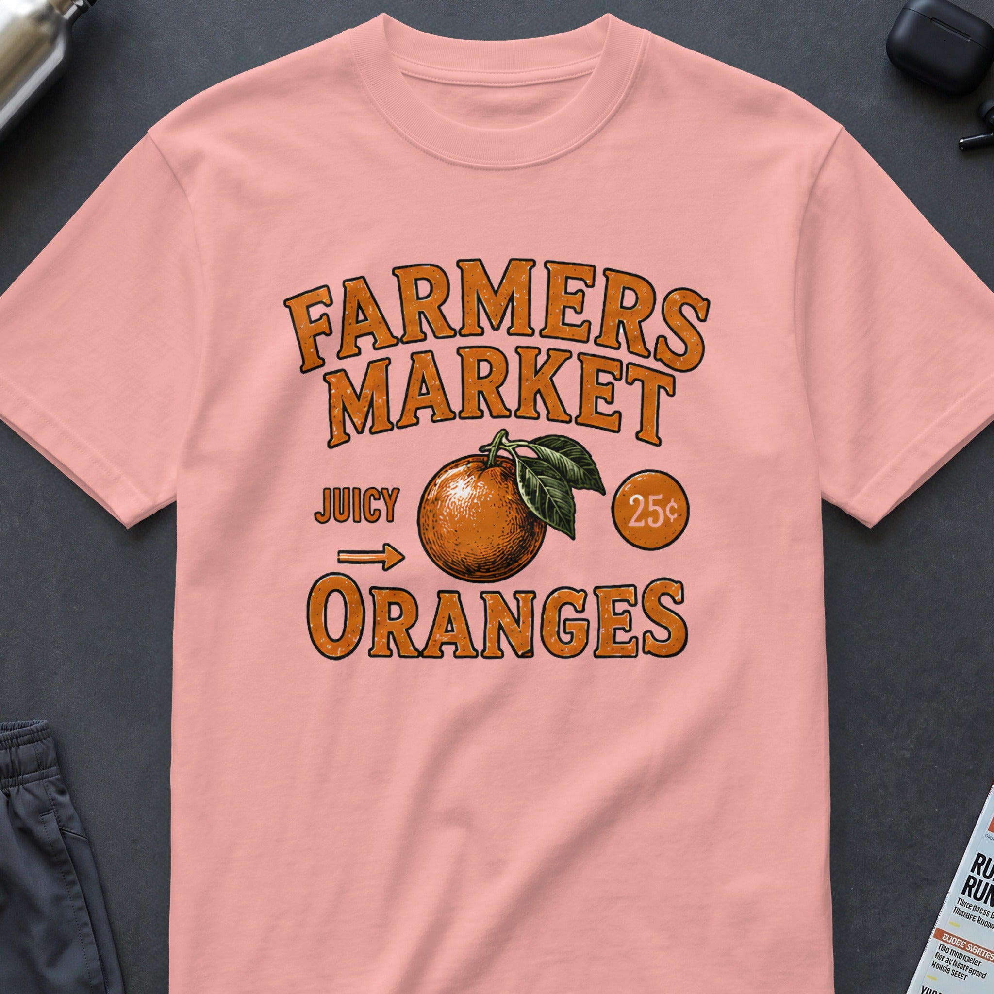 Pink t-shirt with "Farmers Market Juicy Oranges 25¢" graphic.