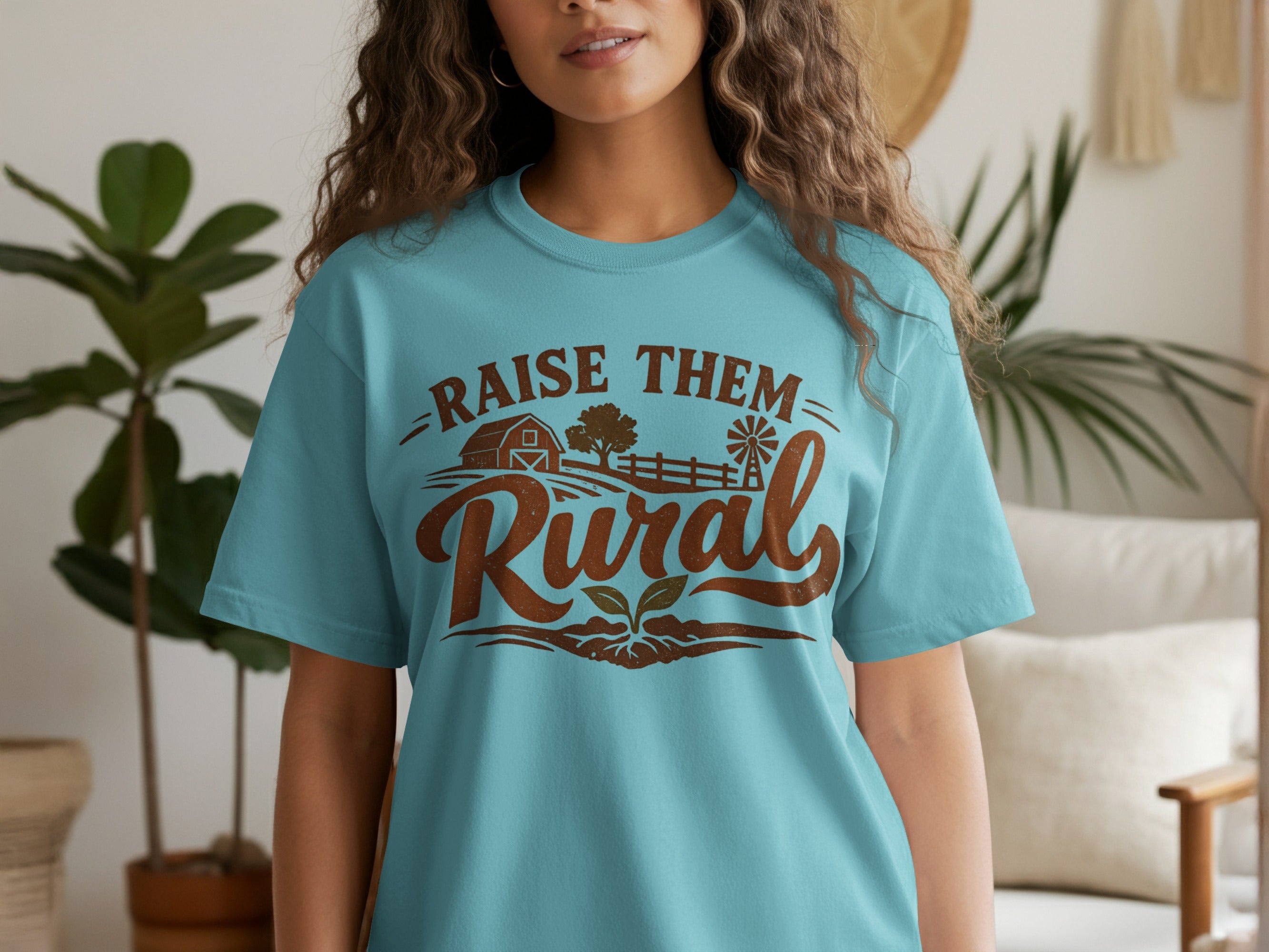 Turquoise t-shirt with "Raise Them Rural" text and farm graphics.