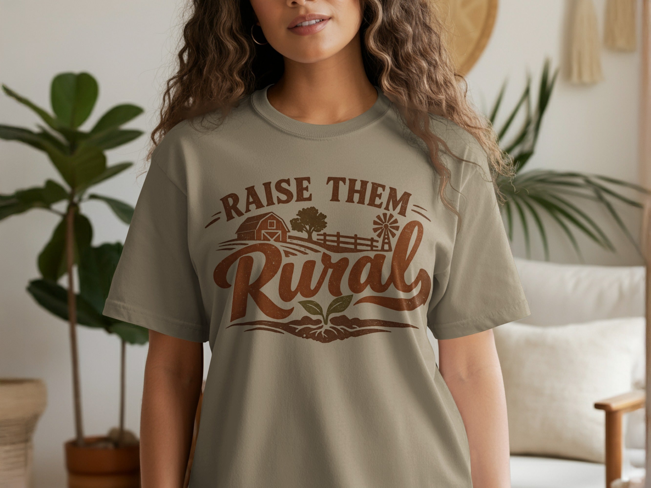 T-shirt with rustic graphic and text "Raise Them Rural" with farm imagery.