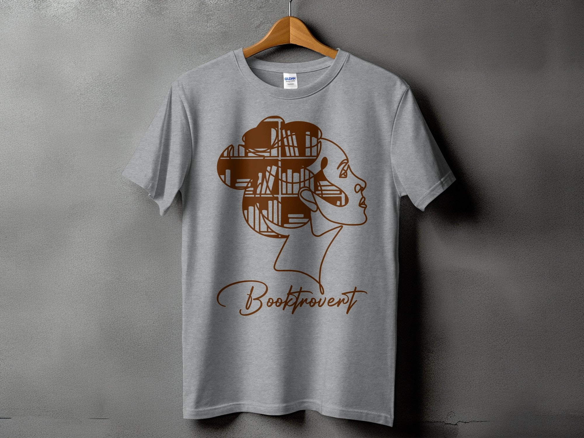 Grey t-shirt with brown graphic of a woman's profile filled with books and the word "Booktrovert".