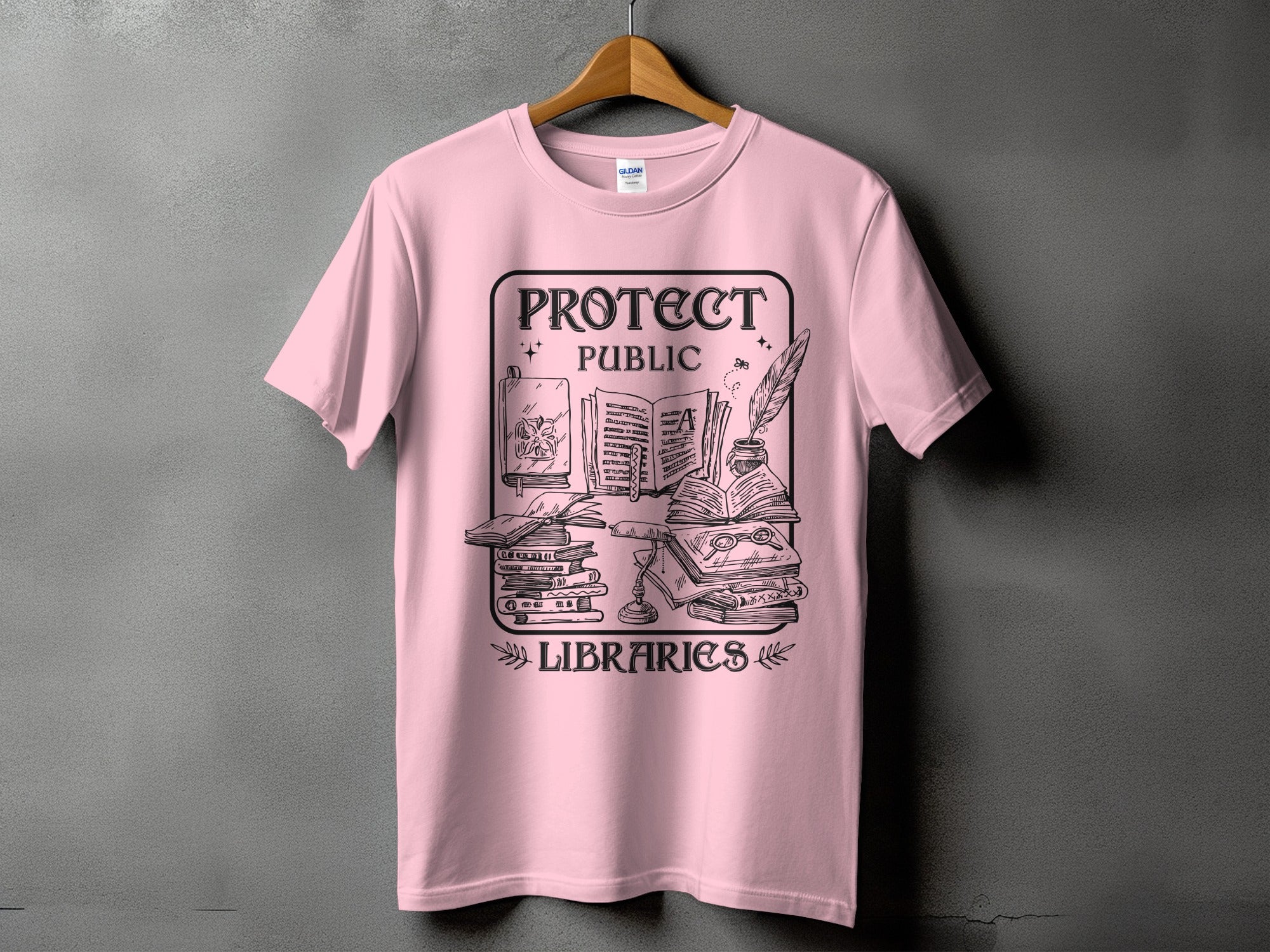 Pink t-shirt with "Protect Public Libraries" graphic of books and writing tools.