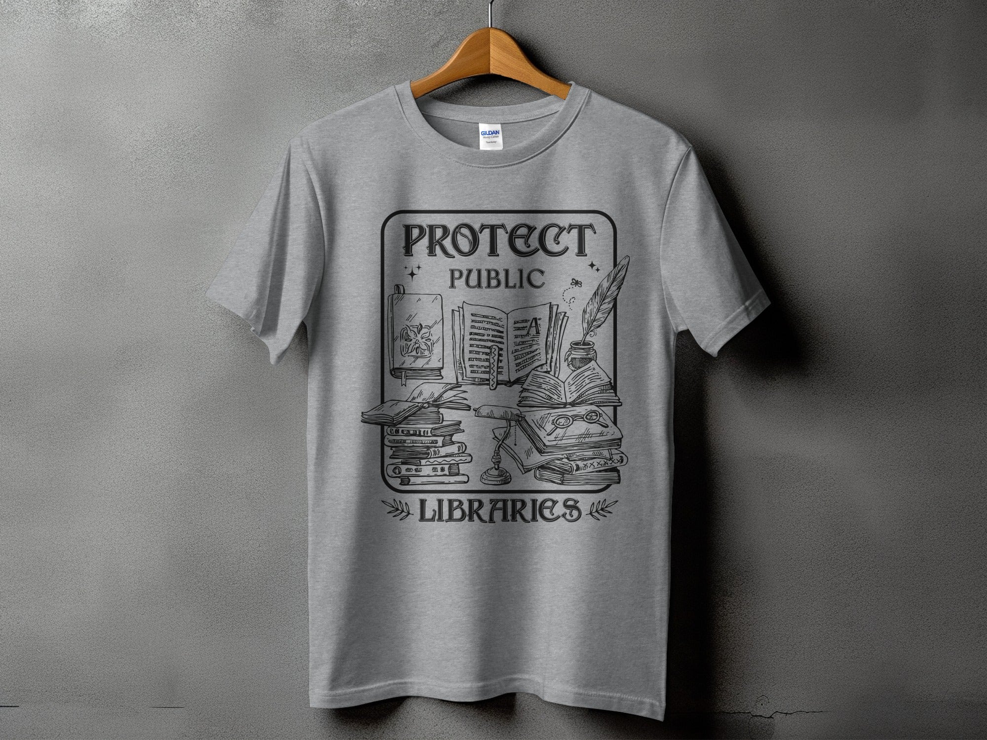 Grey t-shirt with "Protect Public Libraries" graphic featuring books, lamp, and quill.