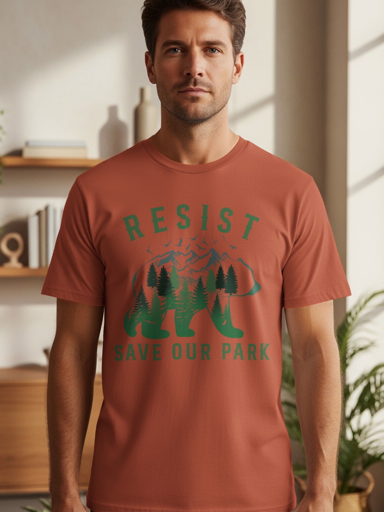 Man wearing rust-colored t-shirt with "RESIST SAVE OUR PARK" and a bear graphic.