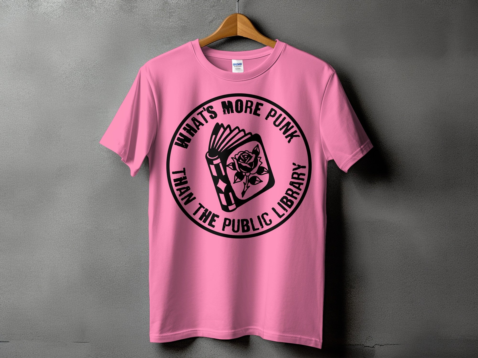 Pink t-shirt with a circular graphic featuring an open book and rose, text reads "What's More Punk Than The Public Library".