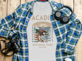 White t-shirt with Acadia National Park Maine graphic, paired with plaid shirt.