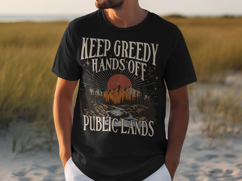 Black t-shirt with "KEEP GREEDY HANDS OFF PUBLIC LANDS" text and mountain landscape graphic.