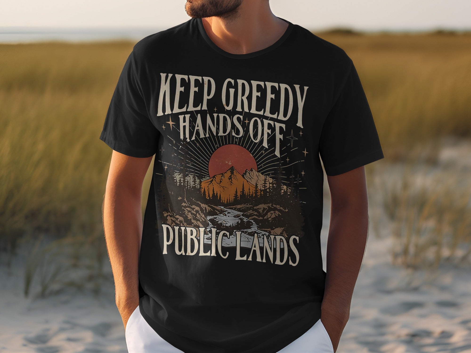 Black t-shirt with "KEEP GREEDY HANDS OFF PUBLIC LANDS" text and mountain landscape graphic.