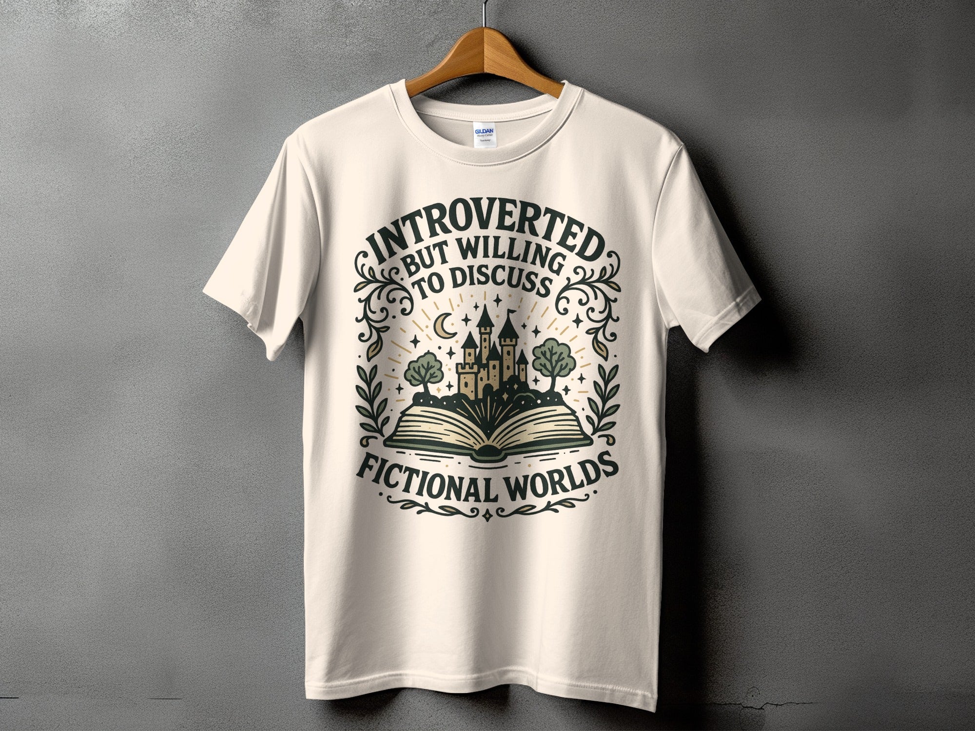 Cream t-shirt with "Introverted but willing to discuss fictional worlds" text and castle on book graphic.