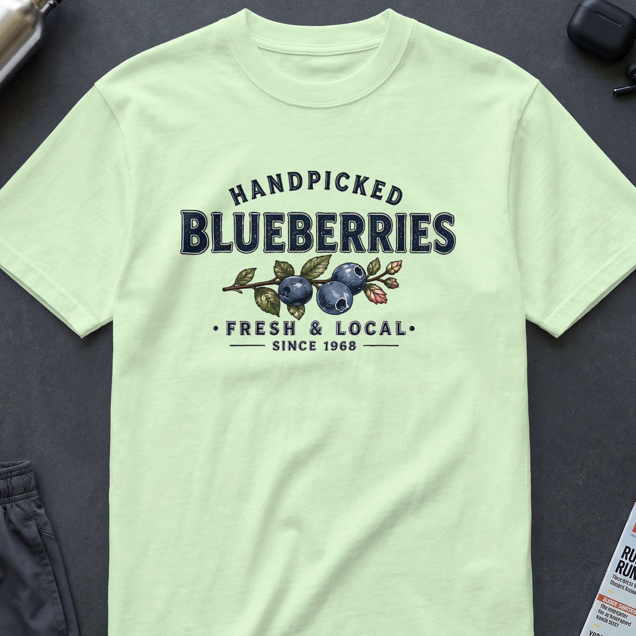 Handpicked blueberries graphic with fresh and local since 1968 text on a pale green shirt.