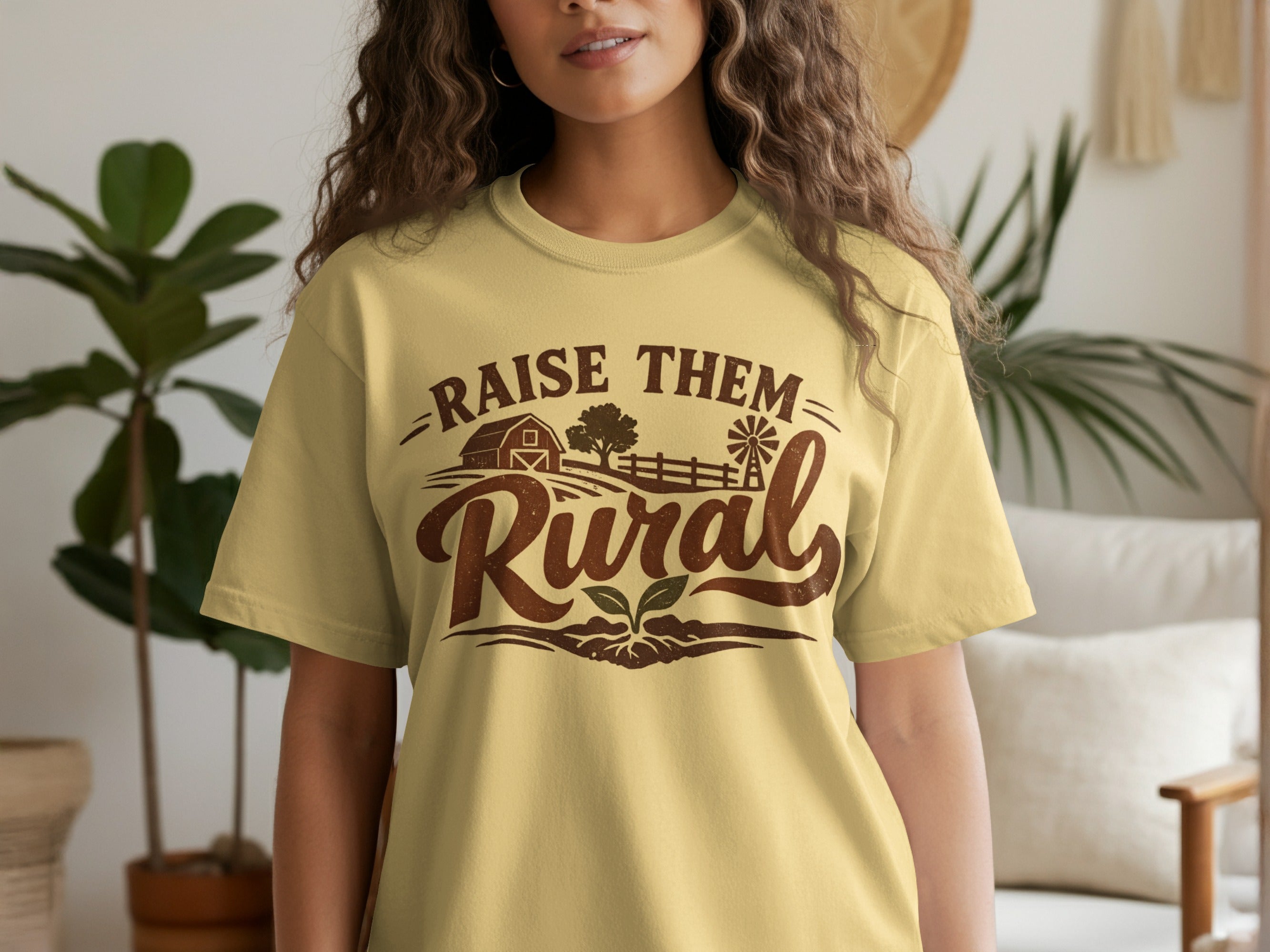 Woman wearing a yellow t-shirt with "Raise Them Rural" text and farm graphic.