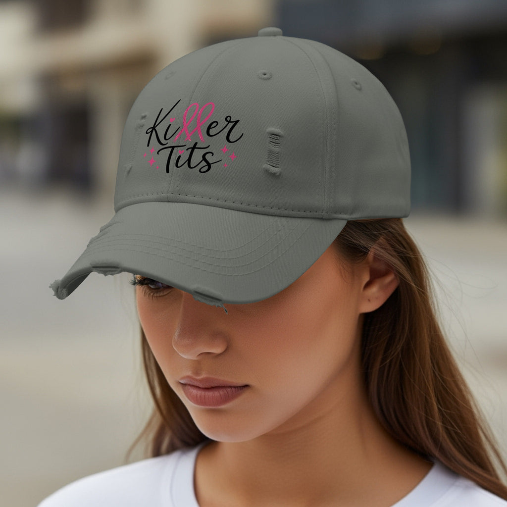Distressed gray baseball cap with "Killer Tits" text and pink accents.