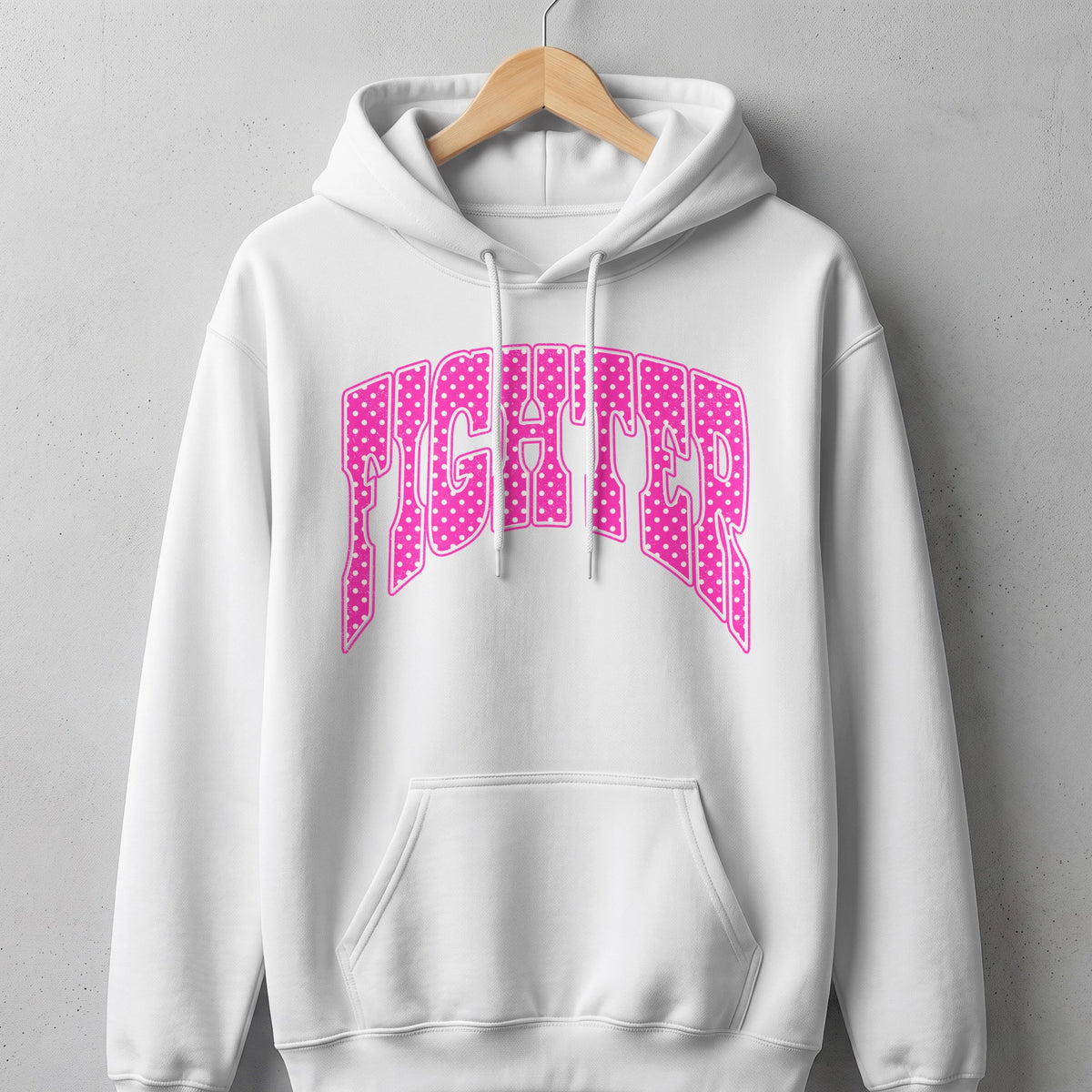 White hoodie with pink polka dot text reading "FIGHTER" across the chest.