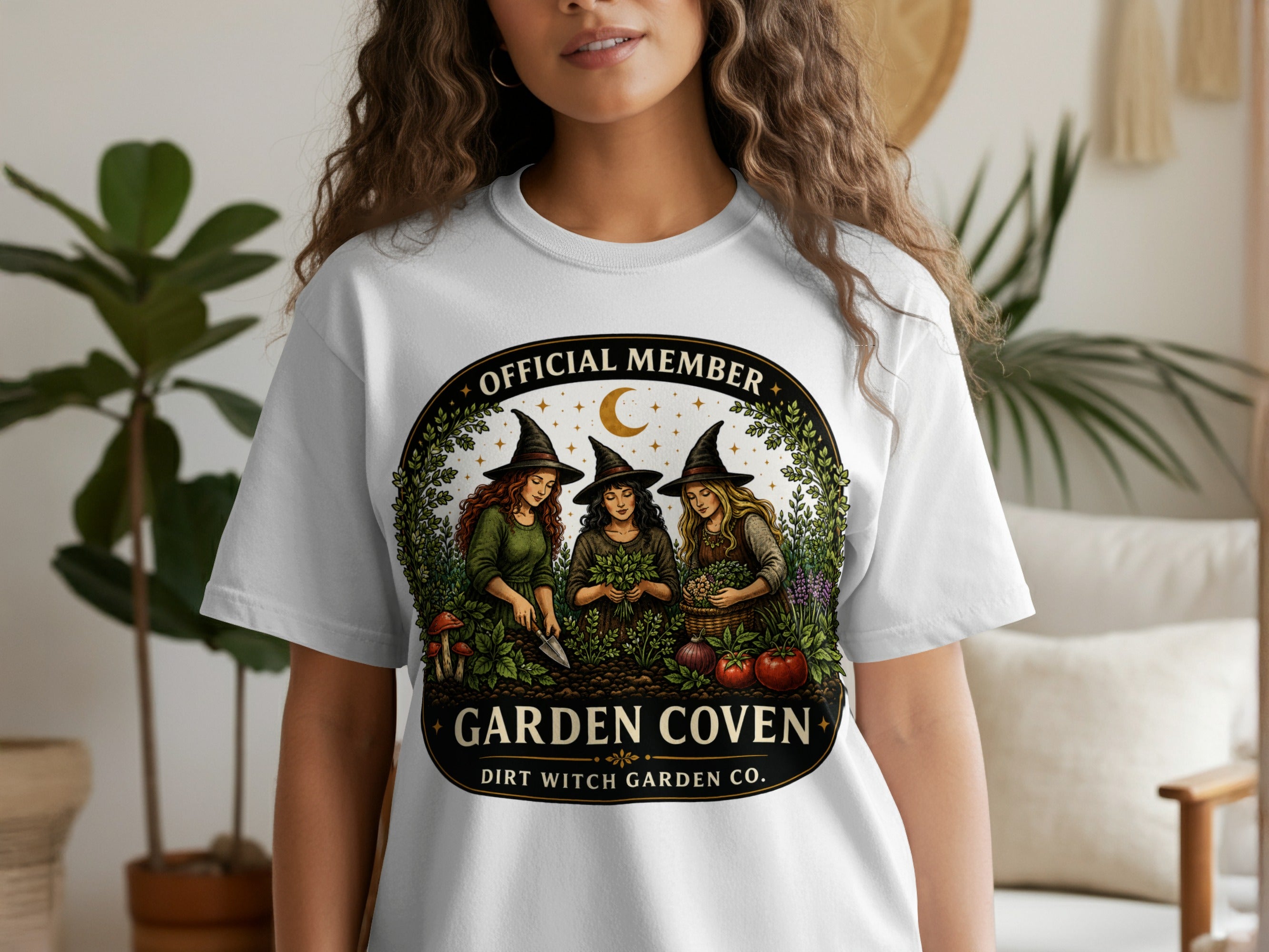 White t-shirt with "Garden Coven" and "Dirt Witch Garden Co." text and witch illustration.