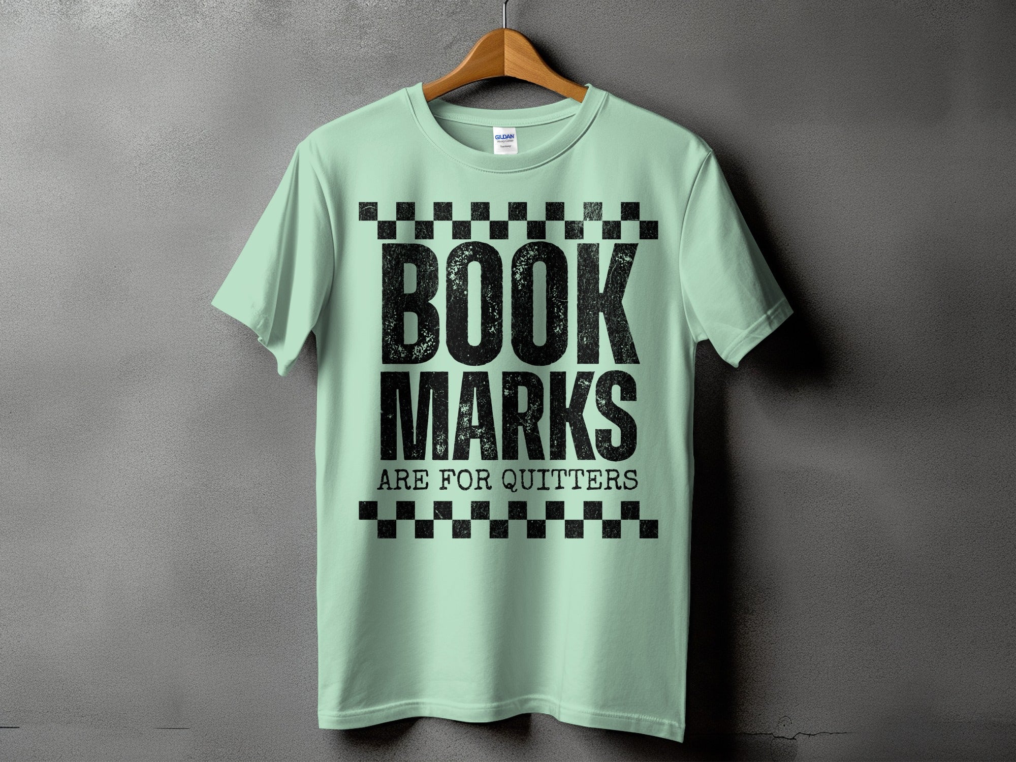 Light green t-shirt with black text that reads "BOOK MARKS ARE FOR QUITTERS."