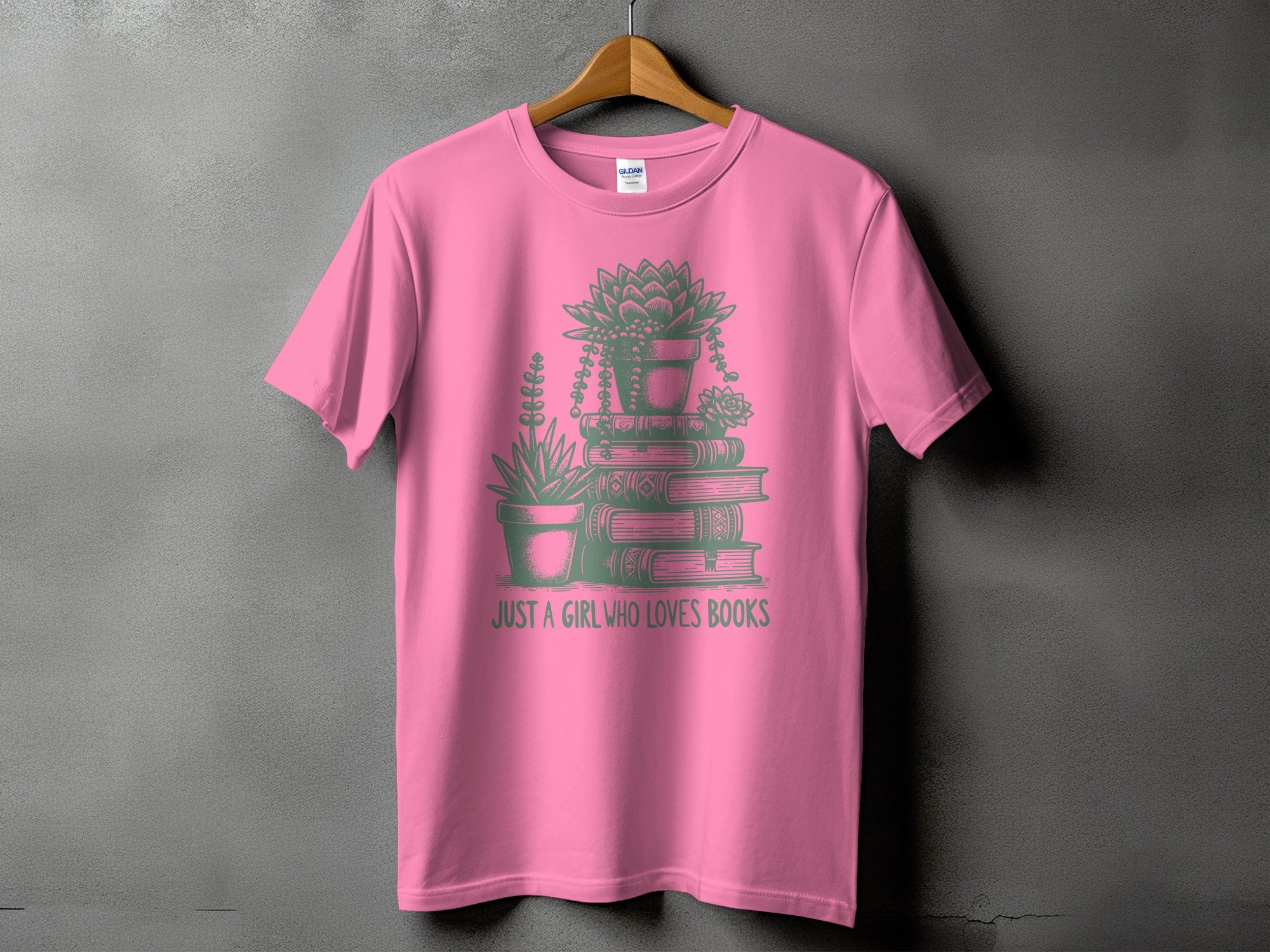 Pink t-shirt with stacked books, potted plants, and "Just a girl who loves books."