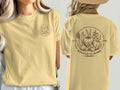 Yellow t-shirt with circular logo featuring vegetables, herbs, and text "Rooted in Work" and "Est. 1983".