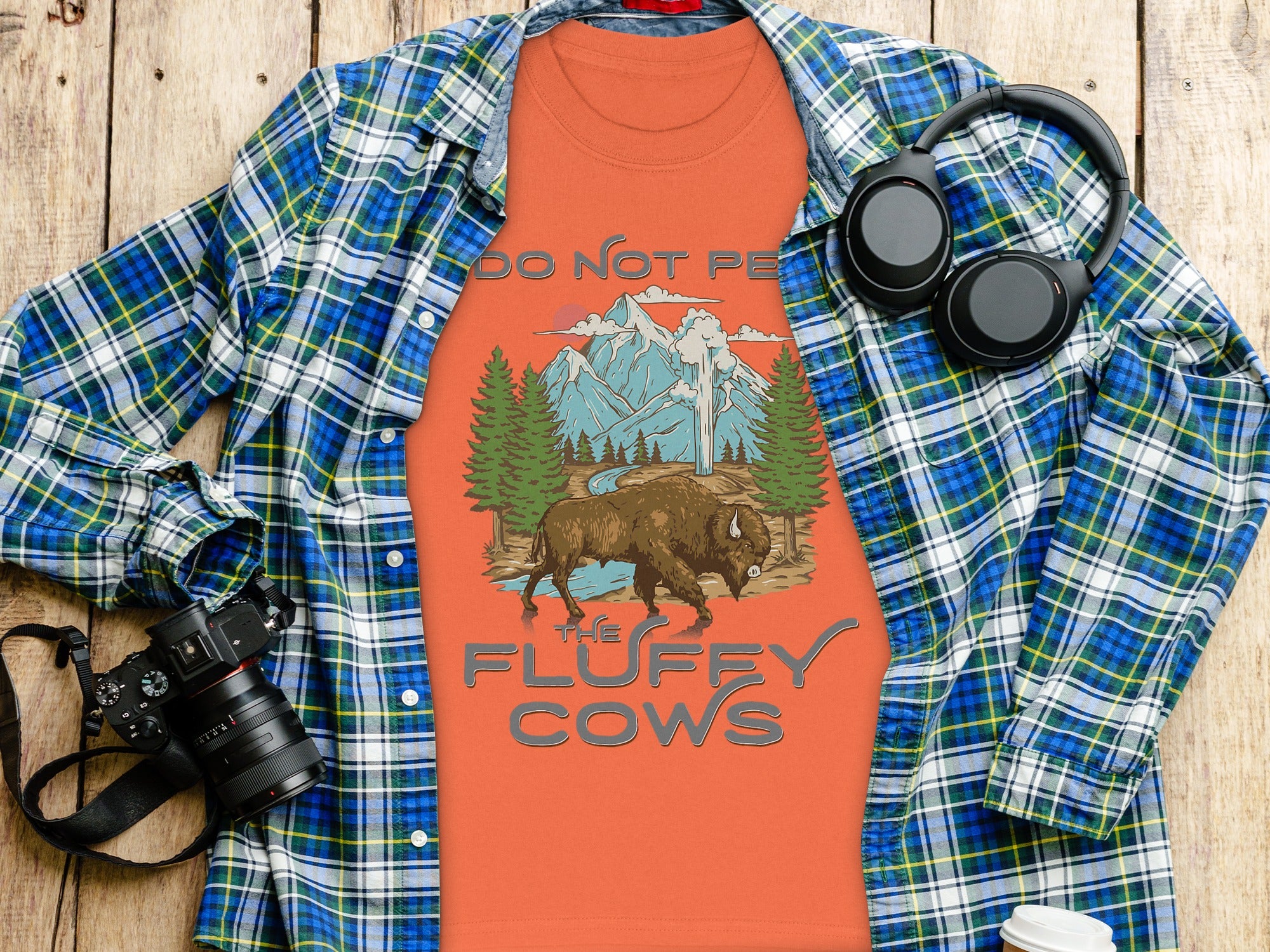 Orange shirt with bison, mountains, and "Do Not Pet the Fluffy Cows" text.
