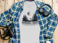 Grey t-shirt with "Forbidden Forest National Park" text and a skeleton unicorn in a forest scene.